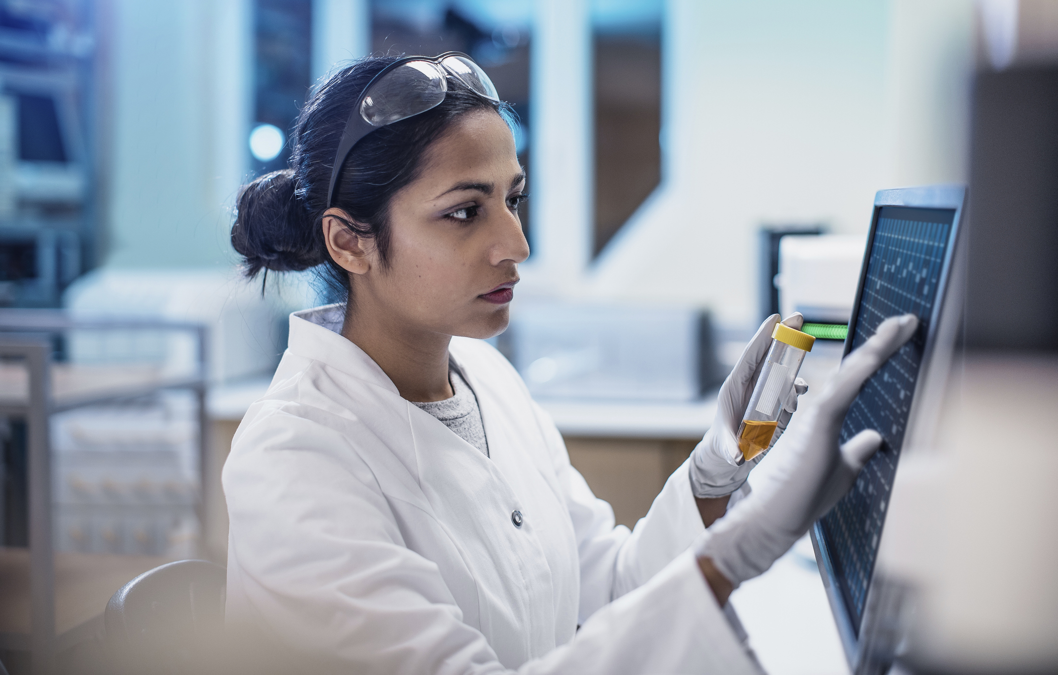 female scientist working in a lab with a computer screen